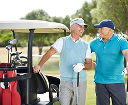 Two men smiling at each other on golf course