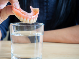 a patient removing their dentures before bedtime